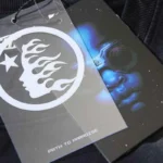 Detail view of the Hellstar Studios Cartoon Logo T-shirt branded hang tag featuring the iconic flame and star graphic.