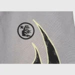 Close-up of Hellstar Studios Flame Grey tracksuit featuring the brand logo and flame pattern on grey fabric