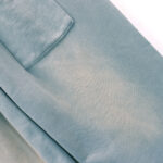 Close-up view of the premium heavyweight grey fleece fabric and pocket detail of Hellstar Studios flame sweatpants.