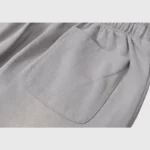 Close-up view of the back pocket on a pair of grey Hellstar Studios unisex cotton tracksuit pants with vintage effect