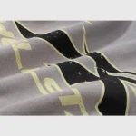 Close-up of the Hellstar Studios Flame Grey tracksuit showing the fabric texture and the unique vintage graphic detail.