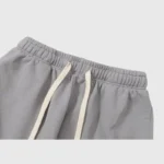 Close-up of the grey cotton fabric and drawstring waistband on the Hellstar Studios Flame Grey unisex tracksuit.