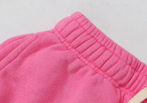 Close-up of the adjustable elastic waistband on Hellstar Studios Flame Sweatpants in a vibrant pink wash colorway.