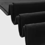 Close-up view of the premium black cotton fabric texture of the Hellstar Studios Flared T-Shirt showing folds.