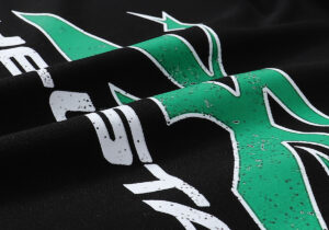 Detailed view of the green and white graphic screen print on a black Hellstar Studios Future Hoodie fabric.