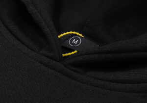 Close-up view of a black Hellstar Studios Future Hoodie showing the interior neck size label marked with an M.