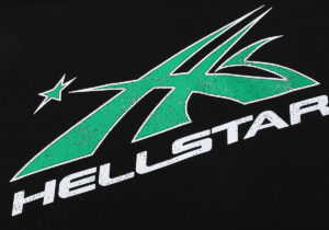 Close-up view of the green and white Hellstar Studios graphic screen print logo detail on a black cotton hoodie fabric.