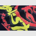 Close-up view of the bold, colorful Heaven on Earth graphic screen print featured on a Hellstar Studios black hoodie.