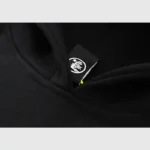 Close-up view of the interior neck brand label on a Hellstar Studios Heaven On Earth black premium fleece hoodie.