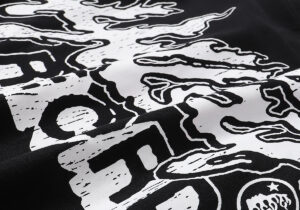 Close-up view of the white graphic print detail on a black Hellstar Studios Heaven Sounds Like T-shirt fabric texture.