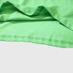 Close-up view of the high-quality lime green cotton fabric from the Hellstar Studios Jesus Emblem graphic T-shirt.