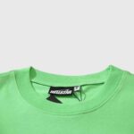 Close-up view of the interior neck tag on a vibrant lime green Hellstar Studios Jesus Emblem crew neck T-shirt.
