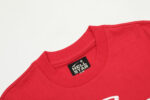 Detail view of the Hellstar Studios brand neck label on a bright red cotton T-shirt from the Jesus Emblem collection.