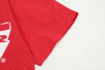 Close up view of the red Hellstar Studios Jesus Emblem T-shirt sleeve showing fabric texture and branding detail.