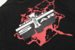 Close up view of the graphic Jesus emblem on a black Hellstar Studios T-shirt with red ink splatter details.
