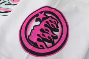 Close-up of the pink Hellstar Studios No Guts No Glory tee logo printed on white fabric