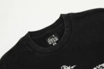 Close up view of the crew neck collar and brand label on a black Hellstar Studios QR Christ graphic t-shirt.