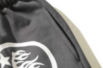 Close-up view of the jet black Hellstar Studios Racer Flare sweatpants highlighting the functional side welt pocket