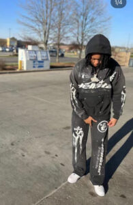 Person wearing Hellstar Studios Racer Flare Sweatpants in jet black with white graphic prints and matching hoodie.