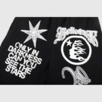 Close-up of the Hellstar Studios Racer Sweatpants featuring bold white screen-printed graphics on black fleece fabric.