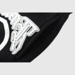 Close-up view of the premium black Hellstar Studios Racer sweatpants featuring a bold white screen printed graphic.