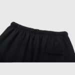 Close-up view of the elastic drawstring waistband on a pair of black Hellstar Studios Racer sweatpants for men.