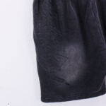 Close-up view of the black vintage-washed fabric and graphic print on Hellstar Studios Records street shorts.