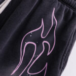 Close-up view of the black Hellstar Studios Records shorts featuring a pink flame and star graphic design.