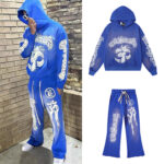 A person wearing the Hellstar Studios Records blue vintage yoga tracksuit set featuring white graphic prints.
