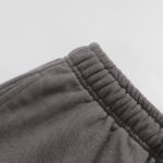 A close-up detail shot of the elasticated waistband on the Hellstar Studios Records grey shorts in a neutral studio.