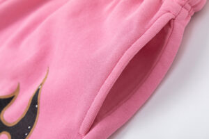 Close-up view of the pocket detail on the pink Hellstar Studios Records vintage wash streetwear shorts.