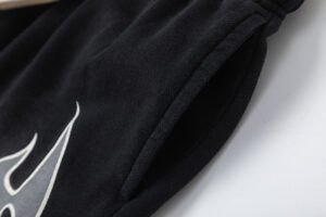 Close-up view of the side pocket and black fleece fabric on the Hellstar Studios Records black streetwear shorts.