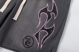 Close up of the graphic design on Hellstar Studios Records jet black shorts featuring flames and a circular logo