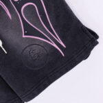Close-up view of the Hellstar Studios Records black fleece shorts featuring a pink graphic design and drawstring detail.