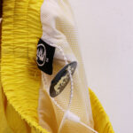 Close-up view of the Hellstar Studios Records Star Shorts in yellow, featuring the branded clothing tag and interior fabric.
