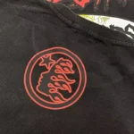 Close-up of the Hellstar Studios Records T-Shirt featuring a circular red graphic logo printed on black cotton fabric.