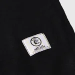 Close-up of the Hellstar Studios Records black tracksuit featuring an integrated NFC authentication tag for verifying item.