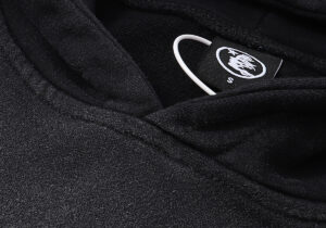 Close up of the Hellstar Studios Records vintage black tracksuit neck label with size S tag details visible on the hoodie.