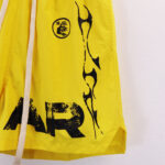 A close-up view of bright yellow Hellstar Studios Records shorts featuring signature black graphic screen-printed details.