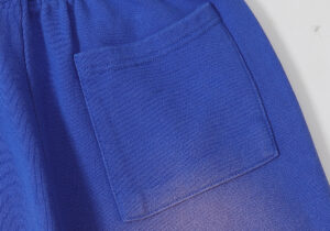 Close-up view of the back pocket detail on the bright blue Hellstar Studios Records yoga sweatpants for men and women.