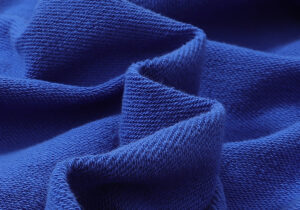 Close-up view of the premium blue cotton fabric used for the Hellstar Studios Records Yoga Hoodie streetwear.