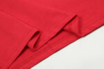 Close-up view of the premium red fabric texture and stitching detail on a Hellstar Studios Jesus Emblem T-Shirt.
