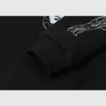Close-up view of the ribbed sleeve cuff and artistic sketch graphic on the black Hellstar Studios hoodie design.