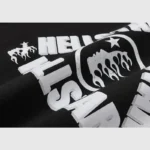 Close-up view of the white Hellstar Studios sketch graphic screen print on a black fleece fabric hoodie.