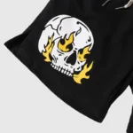 Black Hellstar Studios fleece shorts featuring a white skull and yellow flame screen print graphic and drawstring waist.