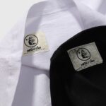 Authentic Hellstar Studios T-shirt neck tags on black and white fabric, showing NFC authentication branding detail.