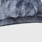 Close-up of the Hellstar Studios washed grey hooded sweatshirt featuring a front pocket and ribbed hem detailing.