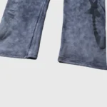 Detail view of the Hellstar Studios washed grey tracksuit joggers featuring signature graphic branding prints.