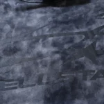 Close-up view of the Hellstar Studios logo featured on the premium heavyweight washed grey cotton fleece tracksuit fabric.