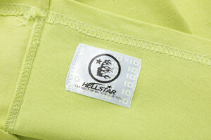 Official Hellstar Studios authentication tag on a yellow short sleeve t-shirt with brand logo and security features.